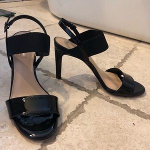 Black patent two-strap stiletto heels.